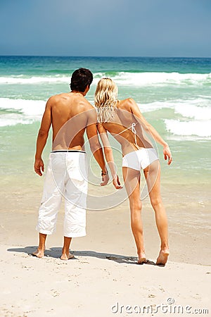 couple-standing-beach-looking-ocean-8701135.jpg